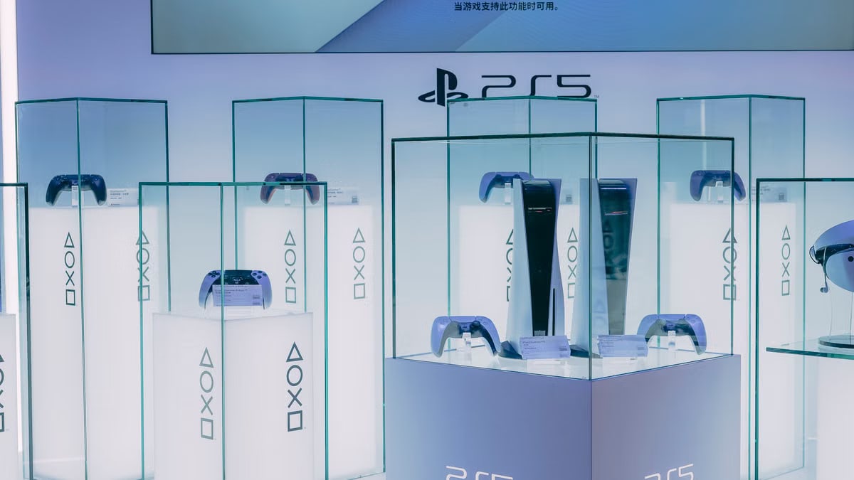 PlayStation 5 consoles and accessories on display in a sleek, futuristic showroom.